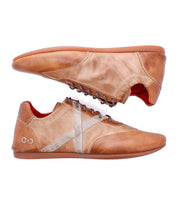 Two Bingo II sneakers by Bed|Stü—crafted from tan leather with white accents, brown EXTRALIGHT outsoles, and a red interior lining using Goodyear construction—are displayed in side profile, one upright and the other upside down.