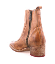 The Bed|Stü Bitsy is a tan leather ankle boot featuring a square toe, side zipper, low stacked heel, and a worn-in look, photographed against a white background.