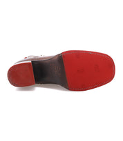 The image shows the bottom view of the Bed|Stü Bitsy brown leather dress shoe, featuring a red rubber sole and heel with brand markings and textured grip patterns—elements characteristic of quality leather boots. Its distinct stacked heel adds a modern touch that enhances the sophistication of the design.