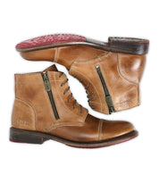 The Bonnie II by Bed|Stü is a pair of tan leather combat ankle boots featuring laces, cap toe detailing, side zippers, and red rubber soles, displayed from the side and bottom views on a white background.