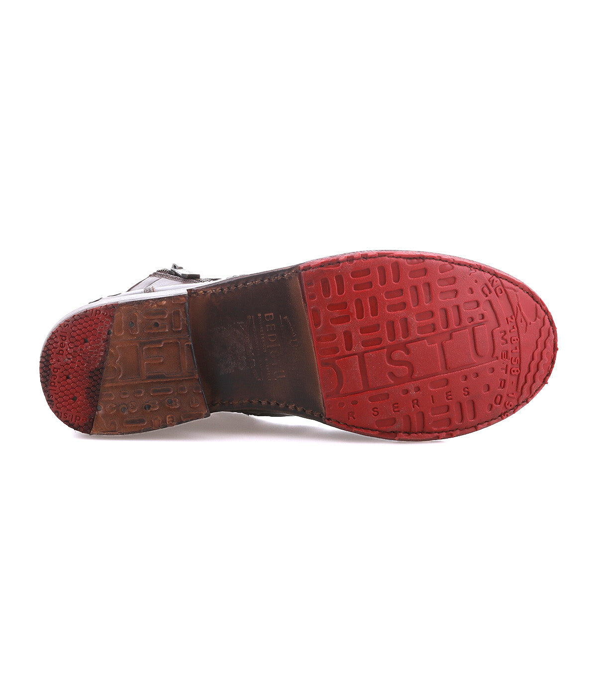 The image displays the bottom view of the Bed|Stü Bonnie II dress shoe, highlighting its red and brown sole with embossed patterns and text. This classic cap-toe design features a Goodyear-welted outsole for enhanced durability.