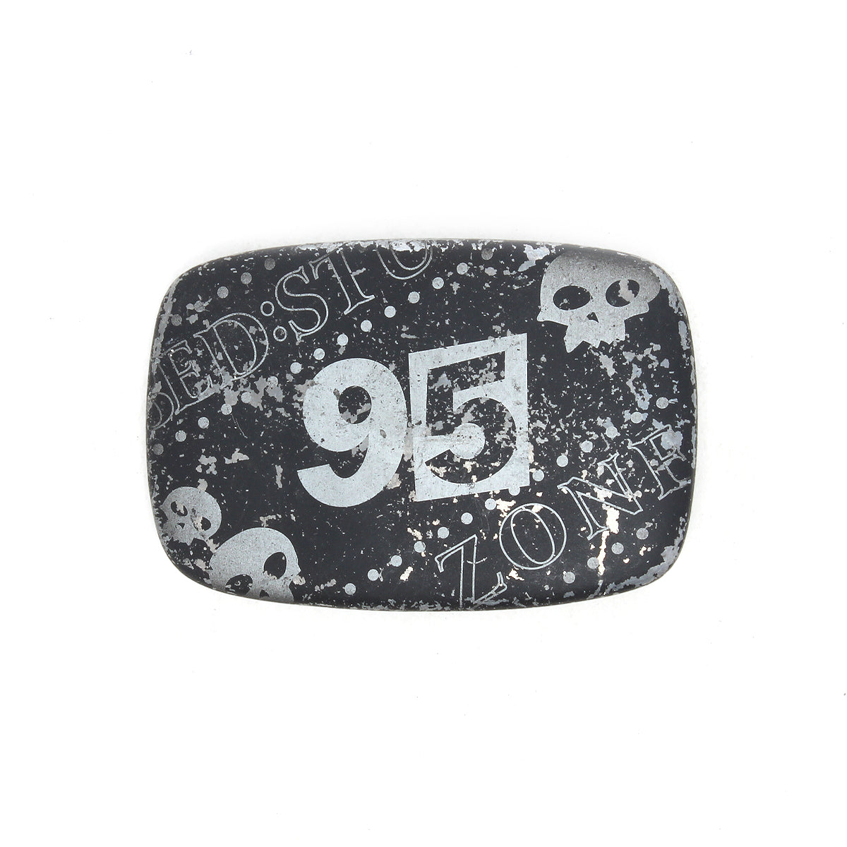 The Bed|Stü 95 Buckle is a rectangular black metal belt buckle with a distressed design, featuring the number "95," white skull graphics, and the partial words "ZONE" and "BEDSTO." This rugged accessory stands out with its unique weathered look.