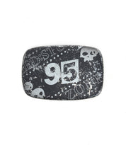 The Bed|Stü 95 Buckle is a rectangular black metal belt buckle with a distressed design, featuring the number "95," white skull graphics, and the partial words "ZONE" and "BEDSTO." This rugged accessory stands out with its unique weathered look.
