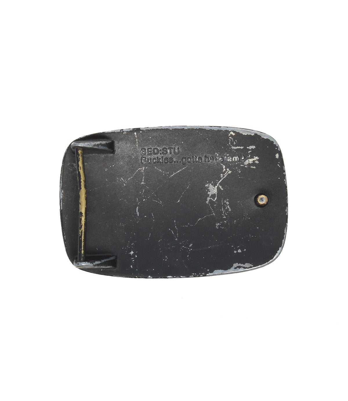 A worn black Bed|Stü 95 Buckle with visible scratches and the text "BEDSTU Buckles... gotta have 'em" rests on a plain white background, capturing the rugged charm of this classic Bed|Stü belt buckle.