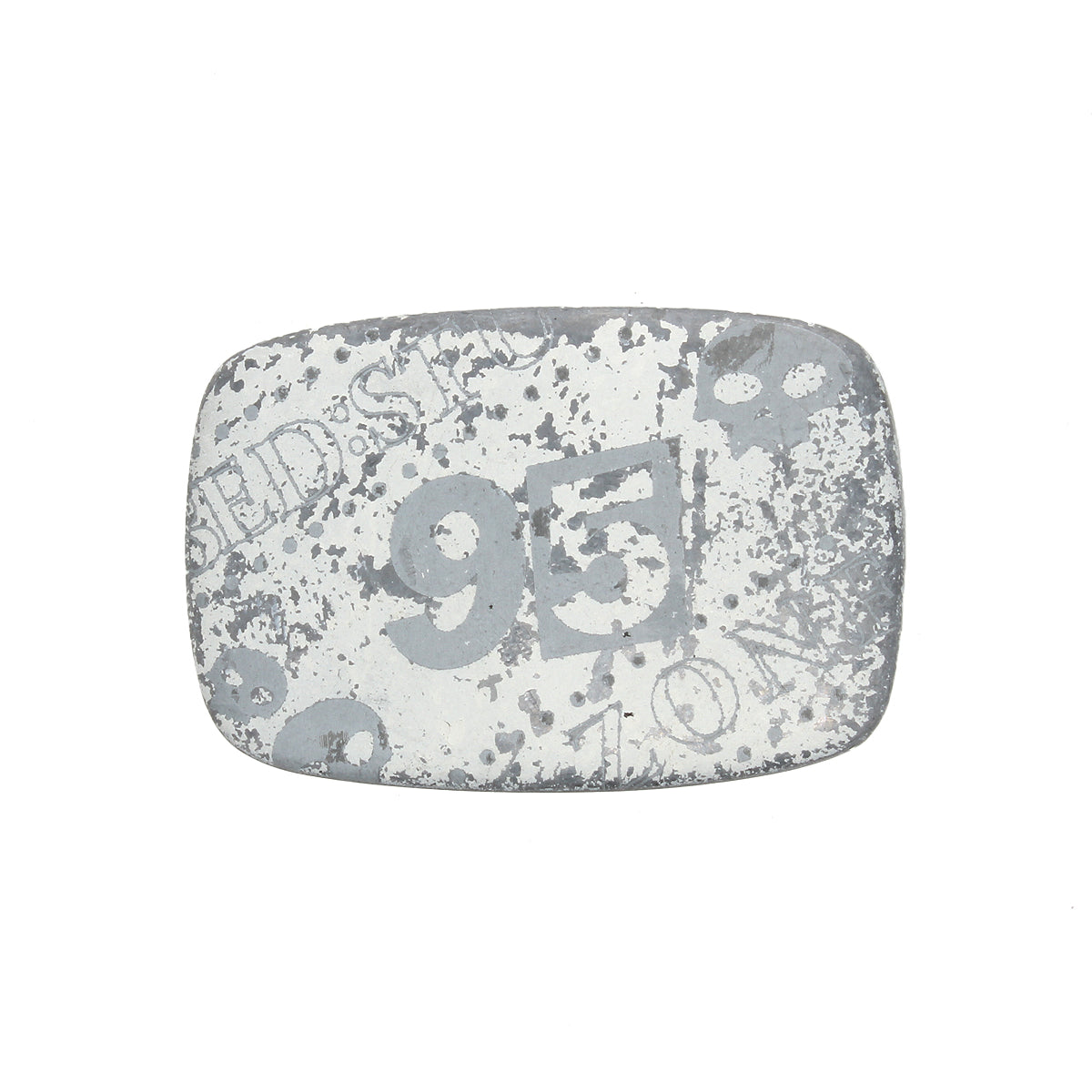 A rectangular, weathered metal object—a rugged buckle by Bed|Stü called the "95 Buckle"—features faded white numbers, including a prominent "95," along with indistinct text and patterns.