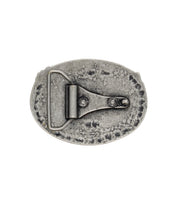 The Bed|Stü Eagle B Buckle is an oval, vintage-style metal belt buckle featuring a weathered finish, a roller bar, and two rivets on the back, displayed against a white background.