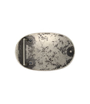 Bed|Stü’s Revolt Buckle features an oval shape in an aged silver-tone finish, showcasing a textured, worn surface and a straightforward fastening bar on the back.