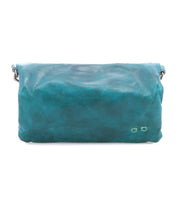 Introducing the Cadence by Bed|Stü—a turquoise crossbody clutch crafted from vegetable-tanned leather. Featuring a flap closure and minimal stitching detail, this stylish accessory is displayed against a white background.