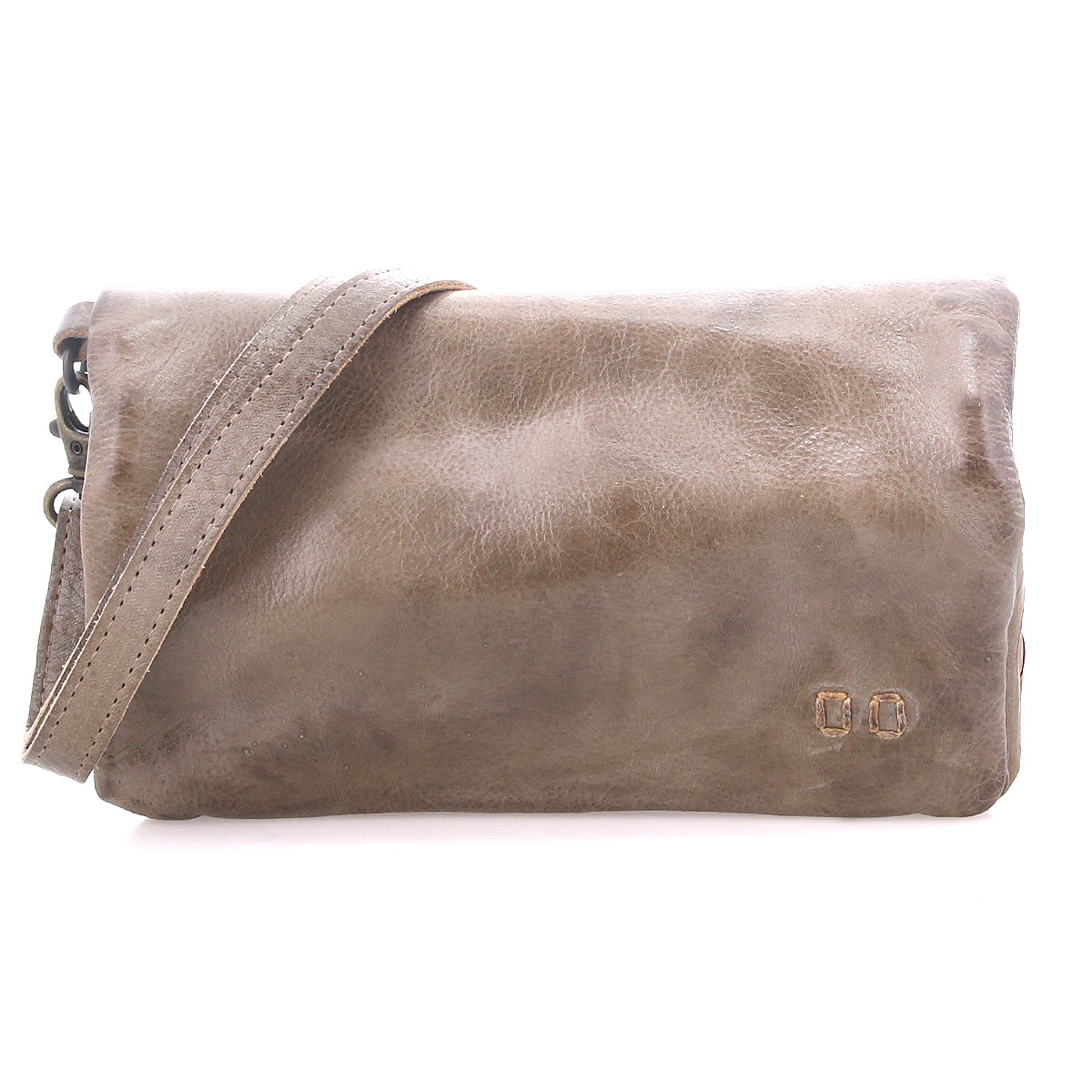 The Cadence clutch by Bed|Stü is crafted from brown vegetable-tanned leather, featuring a wrist strap and two small metal accents on the lower right corner, displayed against a white background.