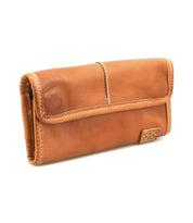 The Bed|Stü Canton is a brown leather wallet with visible stitching, a rectangular shape, and a flap closure accented by a small stitched label on the front—this versatile 2-in-1 accessory doubles as a stylish clutch for effortless organization.