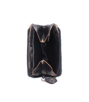 The Bed|Stü "Carrie" compact leather wallet, in black and showing signs of wear, stands open and upright with its zipper visible against a white background.