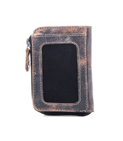 Introducing the Carrie by Bed|Stü—a compact leather wallet in brown and black tones, showcasing visible stitching and a transparent ID window. This upright design on a white background features convenient card slots and a secure zip compartment for your essentials.