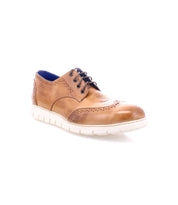 The Bed|Stü Cayuga II brown leather wingtip shoes feature classic brogue detailing with decorative perforations, a white rubber sole, and dark laces, displayed on a white background.