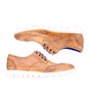 A pair of Bed|Stü Cayuga II light brown leather derby shoes with brogue detailing and white soles, shown from the side on a white background.