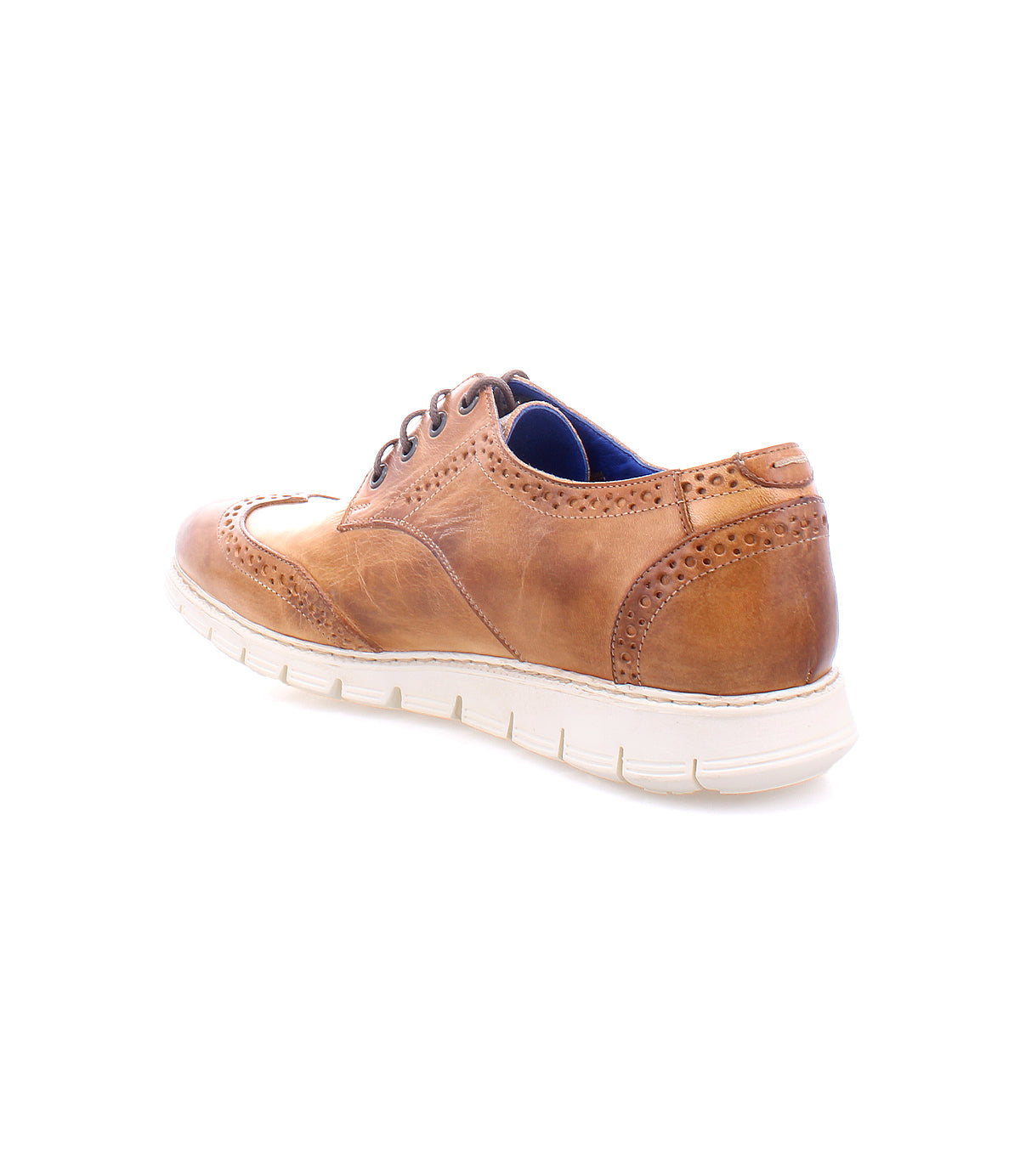 The Cayuga II by Bed|Stü is a tan leather wingtip shoe featuring signature brogue detailing, a white rubber sole, and a blue inner lining, shown from the back left angle.