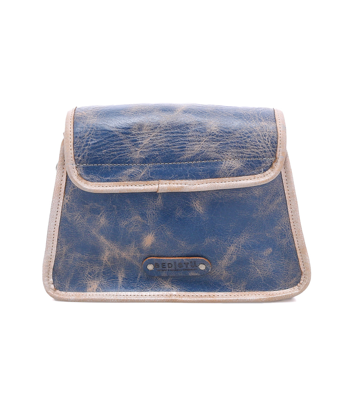 The Ceremonious by Bed|Stü is a small, rectangular blue leather pouch with beige trim, showcasing a preppy flap-top design, magnetic closure, and a branded label on the front.
