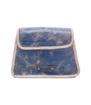 The Ceremonious by Bed|Stü is a small, rectangular blue leather pouch with beige trim, showcasing a preppy flap-top design, magnetic closure, and a branded label on the front.