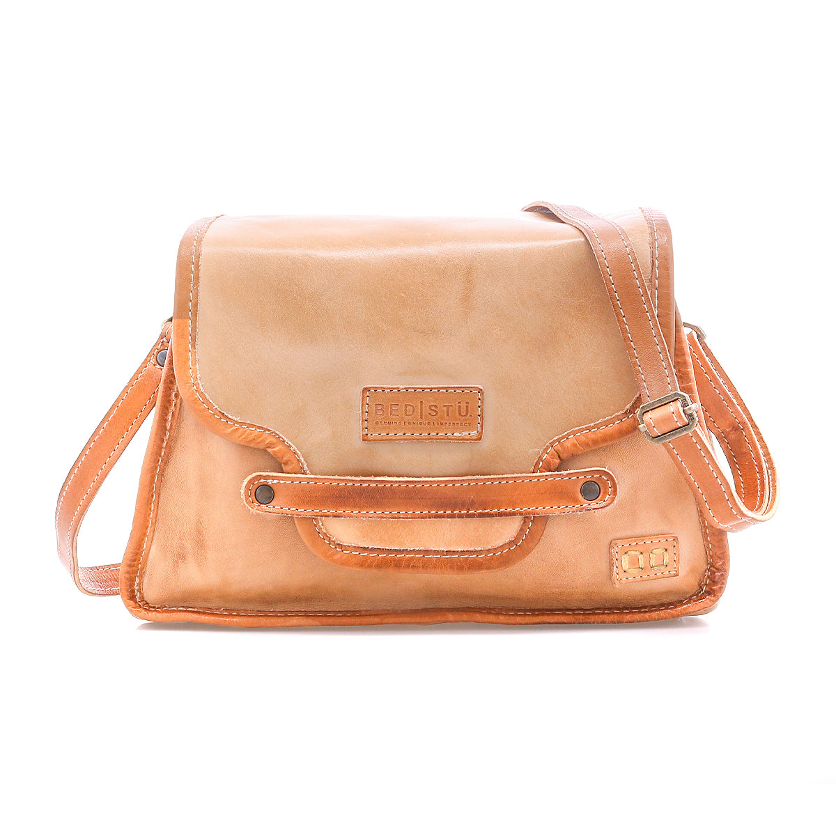 Bed|Stü’s Ceremonious is a tan leather preppy flap-top bag with an adjustable strap, front flap secured by a magnetic closure, stitched detailing, organized interior, and an embossed Bed|Stü logo on the front.