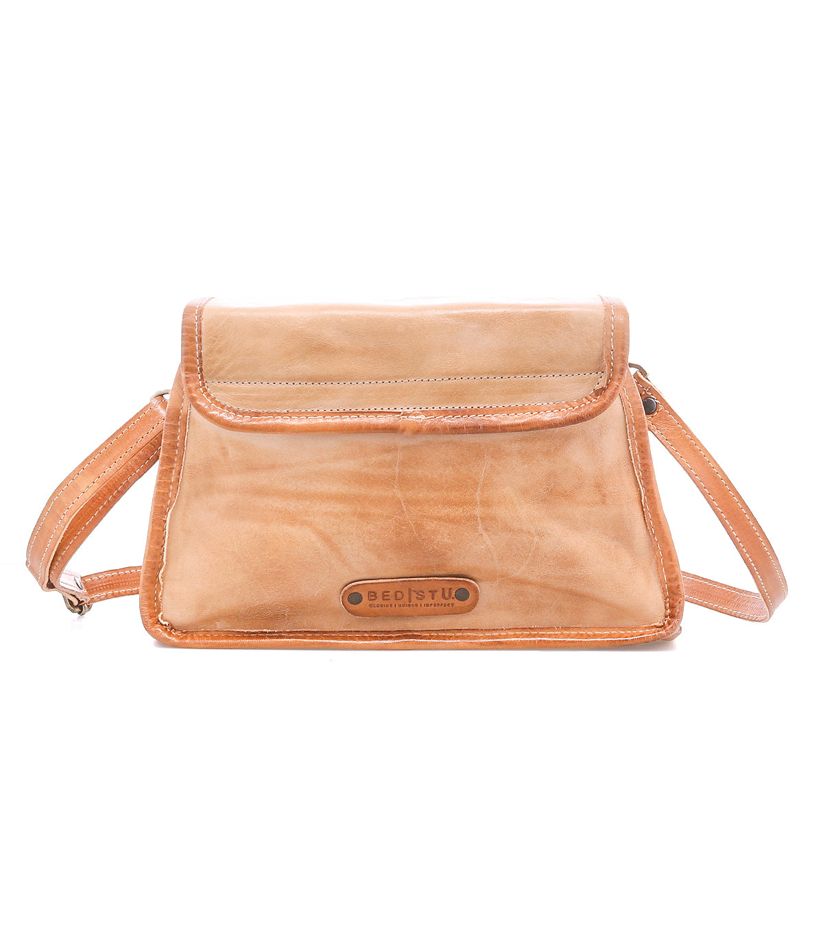 Introducing Ceremonious by Bed|Stü—a light brown preppy leather flap-top bag featuring visible stitching and a long adjustable strap. The magnetic closure keeps your essentials secure, while the thoughtfully organized interior offers a place for everything. The front is adorned with the Bed|Stü brand label.