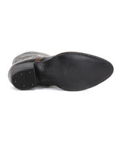 The image shows the bottom view of the Bed|Stü Chamise, a black leather dress shoe featuring a pointed toe and stitched sole that highlights the refined craftsmanship characteristic of this style.