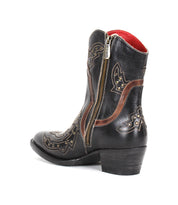 The Chamise boot by Bed|Stü is a stylish black leather ankle cowboy boot featuring decorative stitching, brown accents, a silver side zipper pull, and a short heel. This mid-height western boot also boasts a distinctive red-lined interior for added flair.