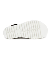 The image displays the bottom view of the Clancy shoe by Bed|Stü, featuring a white sole with a rectangular tread pattern and central branding, emphasizing the supportive design characteristic of platform footwear.