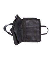 The Bed|Stü Commuter black leather bag is shown laying flat against a white background, displaying its inner compartments and pockets with the strap visible on the left side—perfect for staying organized as a mobile office bag.