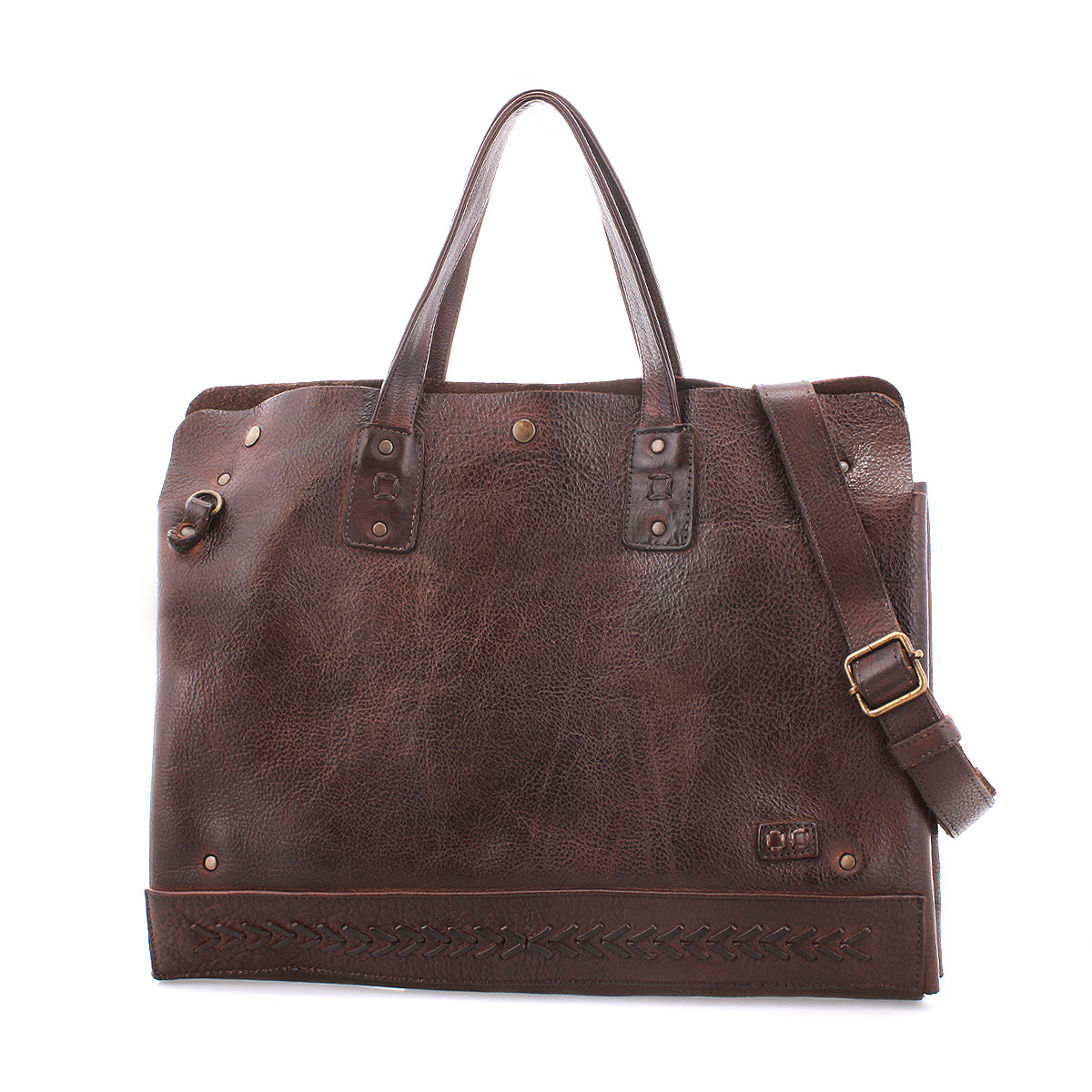 The Bed|Stü Commuter is a brown leather tote bag featuring dual handles, a detachable shoulder strap, brass hardware, and decorative stitching along the bottom edge—ideal as a stylish commuter bag or an elegant laptop bag for your everyday needs.