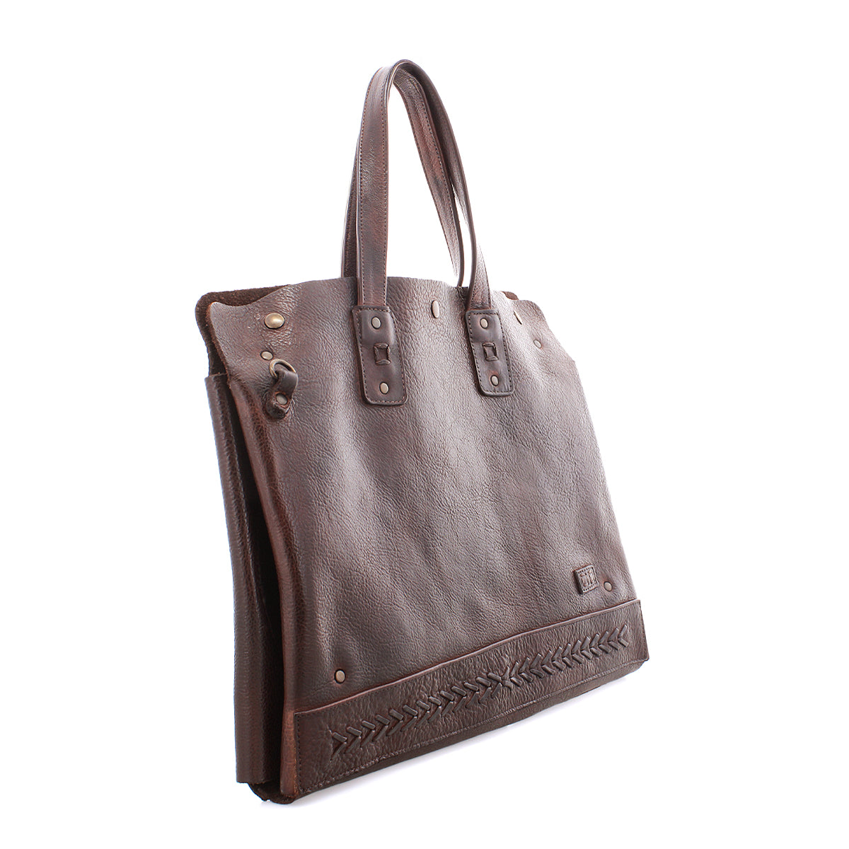 The Bed|Stü Commuter is a brown leather bag featuring two handles, decorative stitching near the base, metal rivets, and a classic rectangular shape. Photographed against a white background, this bag offers both style and functionality—making it an excellent choice for anyone in need of a sophisticated laptop carrier.