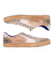 The Condor by Bed|Stü is a pair of low-top leather sneakers in beige and taupe, featuring gum rubber soles, blue inner lining, and detailed side stitching—displayed from the side against a white background. Crafted for comfortable wear and durable construction, these leather sneakers seamlessly blend style with practicality.