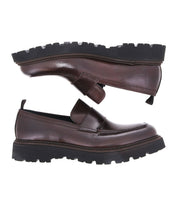 A pair of Costruito brown vegetable-tanned leather loafers by Bed|Stü, featuring thick black chunky Livetech outsoles—one shoe shown sole up above the other—displayed on a white background.
