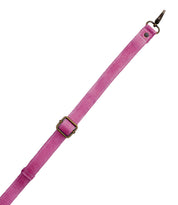 The Bed|Stü Crossbody Strap features an adjustable pink fabric design with a brass-colored buckle and a metal clasp at one end, making it the perfect accessory for pairing with Bed|Stü bags as a crossbody, shown isolated on a white background.
