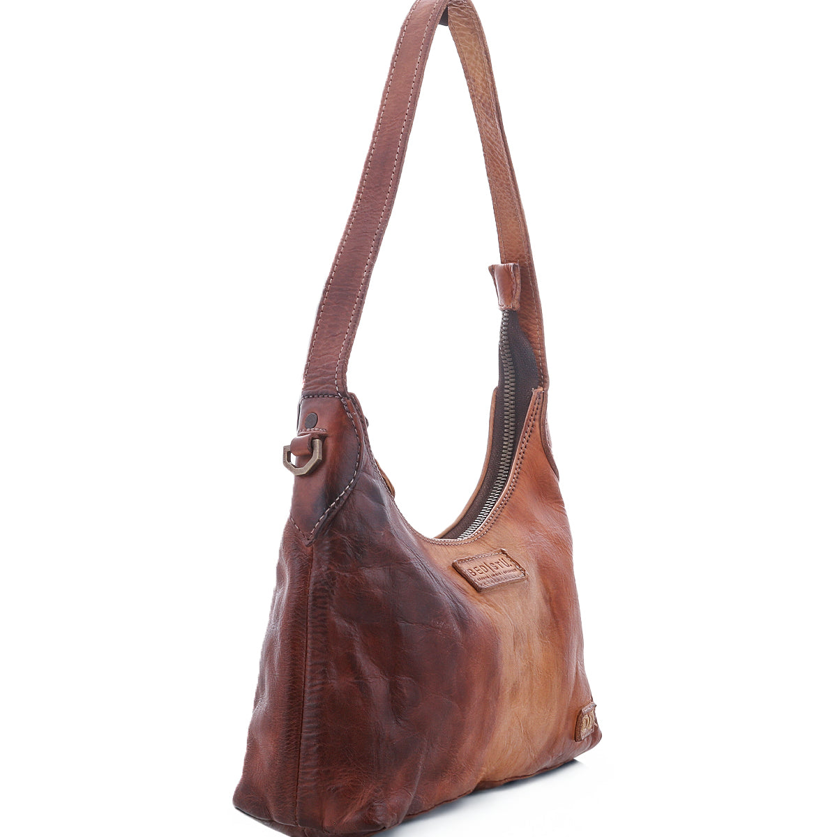 The Denton by Bed|Stü is a brown leather shoulder bag featuring a single strap, visible stitching, and a zip-top closure on the main compartment, expertly crafted from rich vegetable-tanned leather and photographed against a white background.