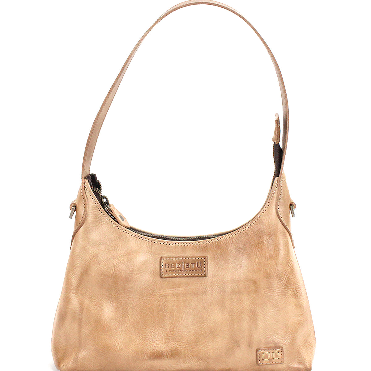 The Denton by Bed|Stü is a small beige bag, expertly crafted from vegetable-tanned leather with an embossed logo on the front, a single shoulder strap, and a zip-top closure.