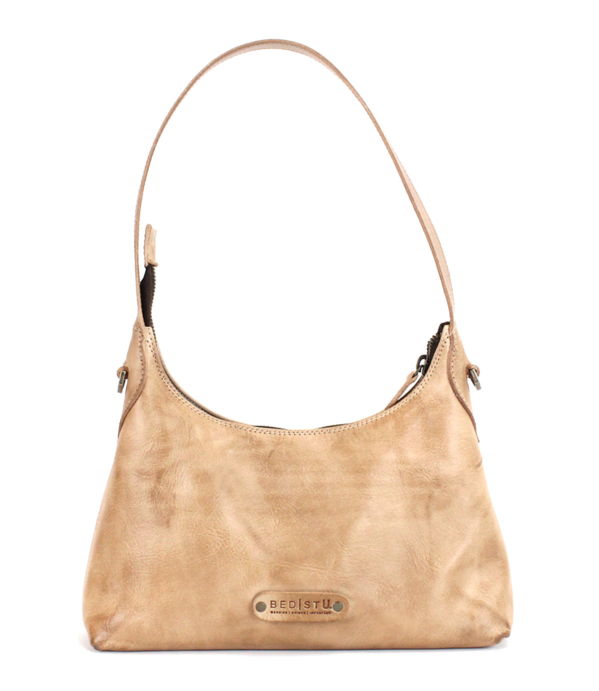 Beige leather shoulder bag, the Denton by Bed|Stü, crafted from premium vegetable-tanned leather and featuring a single strap, secure zip-top closure, and a metal logo plate on the front. This elegant small bag is perfect for carrying your everyday essentials.