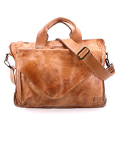 The Bed|Stü Depp messenger bag, crafted in light brown leather, features top handles, an adjustable shoulder strap, a front pocket, visible stitching, and organized compartments—all showcased against a white background.