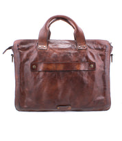 The Depp briefcase by Bed|Stü features brown leather, sturdy handles, organized compartments, and metal hardware, displayed upright against a plain white background.