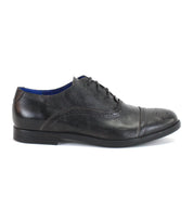 The Donatello II by Bed|Stü is a black leather oxford dress shoe featuring brogue detailing, a cap-toe design, and a black sole, all crafted from premium vegetable-tanned leather, shown here in a side profile view.