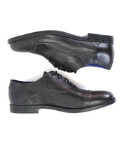 Two Donatello II black leather oxford shoes by Bed|Stü, featuring a sleek cap-toe design, are shown in profile against a white background. One shoe is placed above the other, and both are facing right.