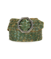 The Bed|Stü Dreamweaver, a green woven leather belt featuring artisan craftsmanship and a silver octagonal metal buckle, is coiled on a white background.