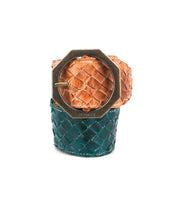 The Dreamweaver cuff bracelet by Bed|Stü showcases artisan craftsmanship with wide woven leather in tan and teal sections, accented by a large octagonal brass buckle for a distinct bohemian style.