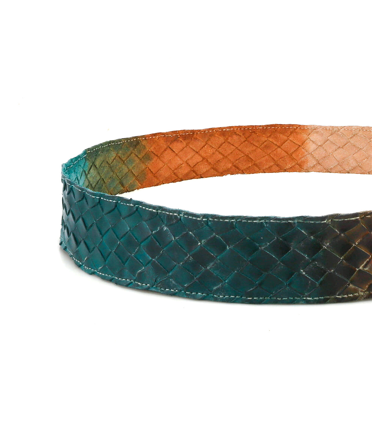 A detailed shot of the Bed|Stü Dreamweaver belt highlights its artisan craftsmanship, featuring a woven teal leather exterior contrasted with a rich brown-orange interior. Set against a white background, this accessory embodies bohemian style through its unique color combination and skilled design.