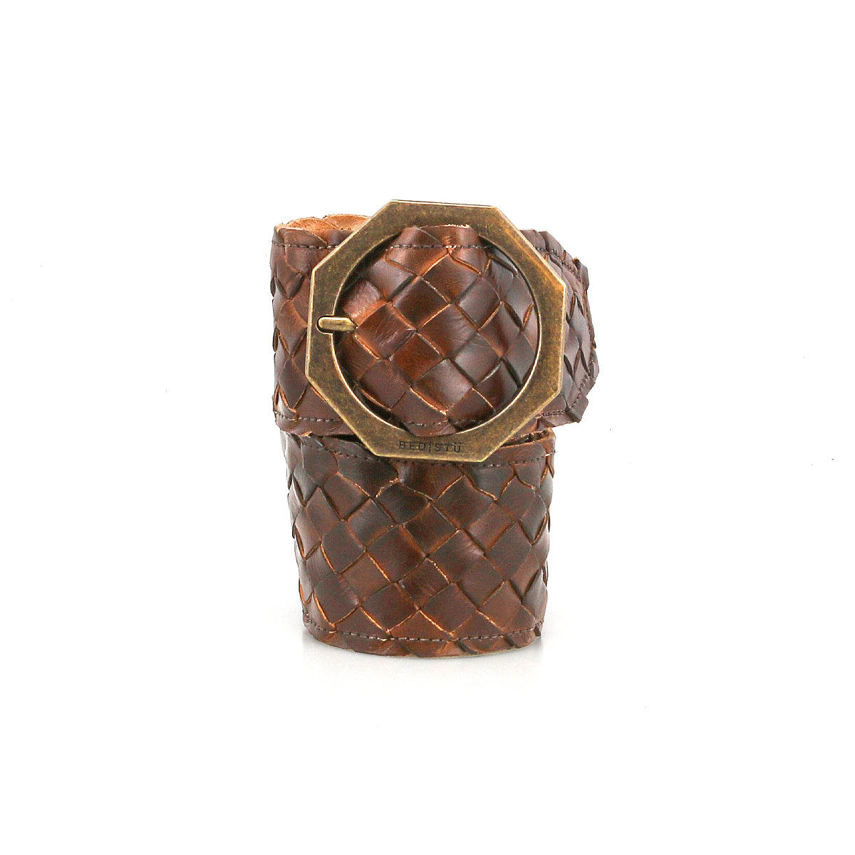 The Dreamweaver bracelet by Bed|Stü showcases artisan craftsmanship and bohemian style with its wide brown woven leather band, accented by a large octagonal brass buckle, and is displayed upright against a white background.