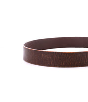 A close-up of the Bed|Stü Drifter brown textured leather strap, looped in a circle with a metal buckle, displayed on a white background in minimal style.