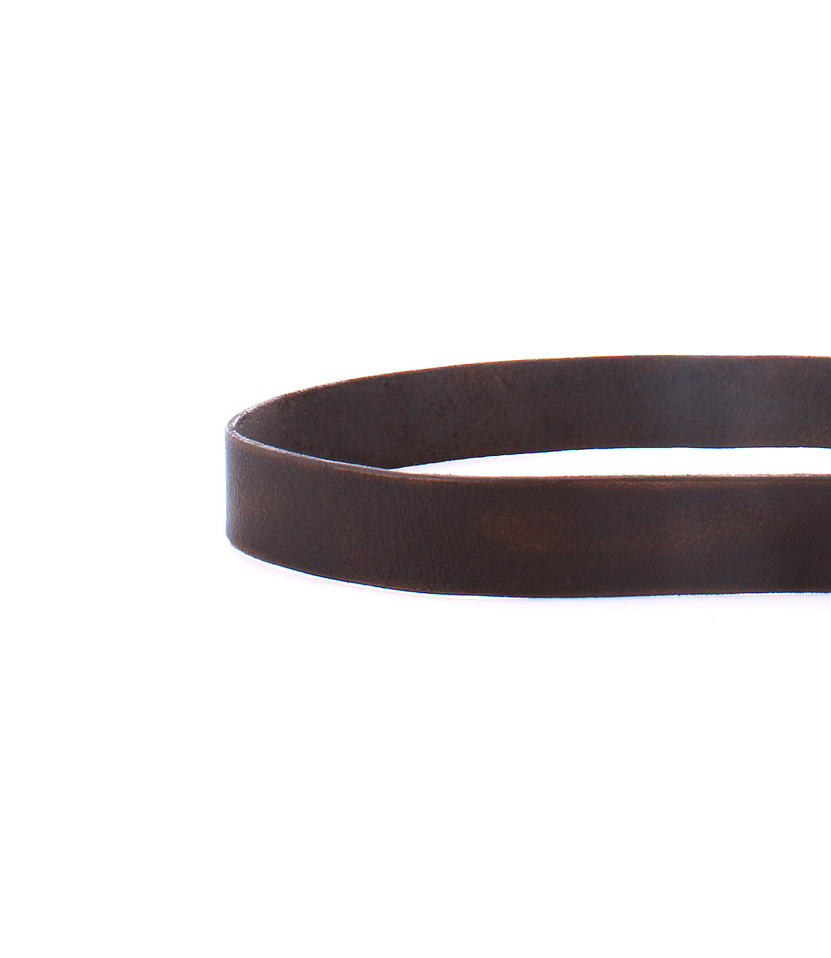 A minimal-style close-up of the Bed|Stü Drifter brown textured leather strap belt, coiled in a circular shape and featuring a metal buckle, photographed on a white background.