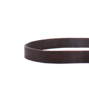 A minimal-style close-up of the Bed|Stü Drifter brown textured leather strap belt, coiled in a circular shape and featuring a metal buckle, photographed on a white background.