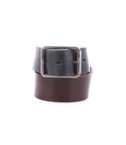 The Drifter by Bed|Stü is a rolled leather belt featuring a rectangular metal buckle and a textured strap, with rich dark brown leather on the outside and black leather on the inside, displayed against a white background for a clean, minimal style.