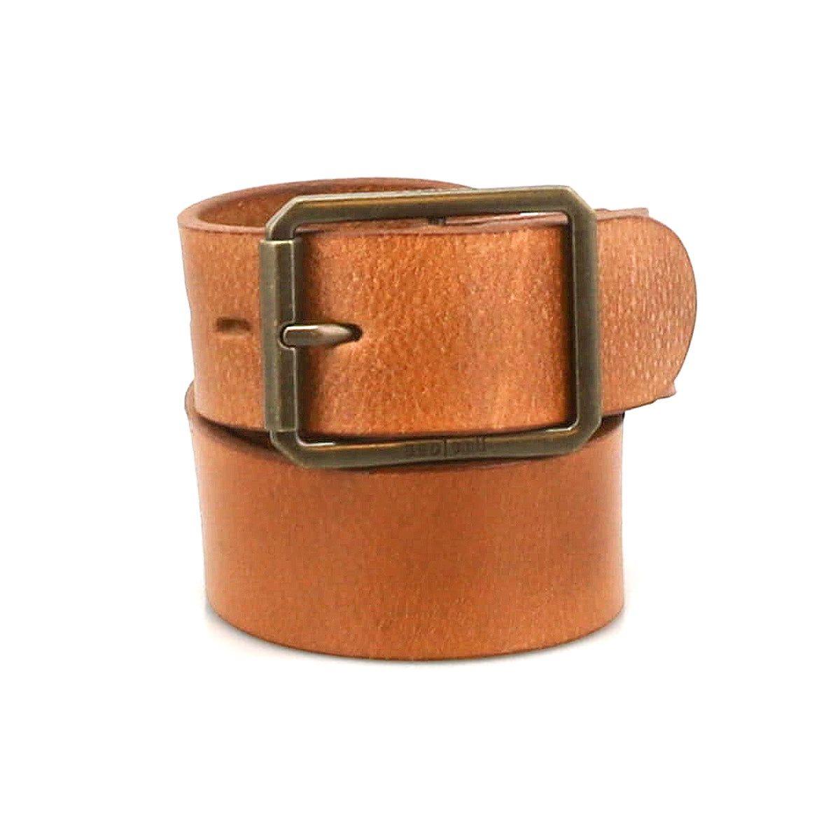 The Drifter belt by Bed|Stü is a tan textured leather strap, rolled up and featuring a rectangular metal buckle, showcased in a minimal style against a white background.