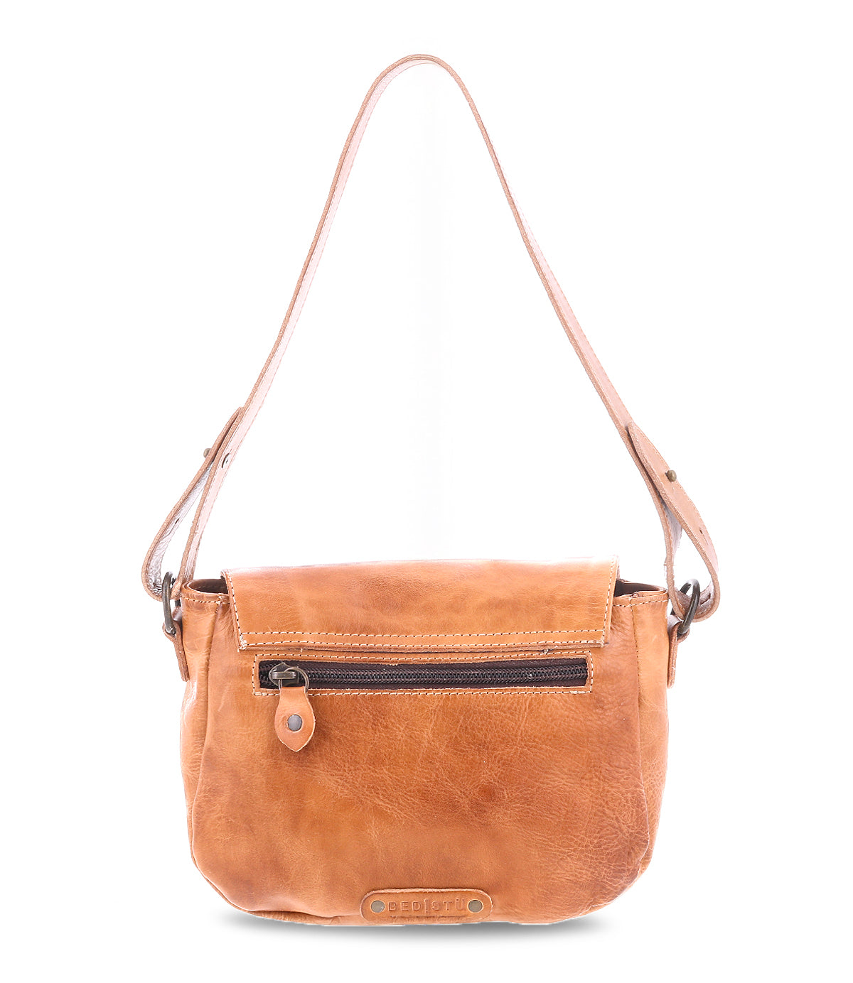 The Bed|Stü Elect is a light brown leather shoulder bag with a front zipper pocket, flap closure, and an adjustable strap. Featuring vintage charm and perfect for everyday use, it is displayed against a white background.