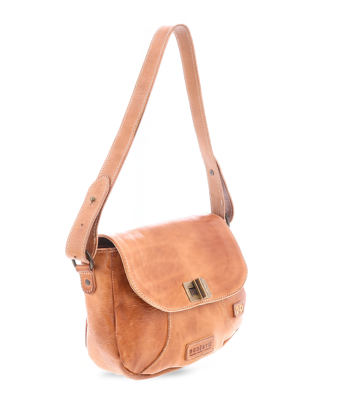 The Elect by Bed|Stü is a light brown leather shoulder bag featuring a front flap, metal clasp, and adjustable strap. Displayed on a white background, this piece blends vintage charm with everyday practicality.